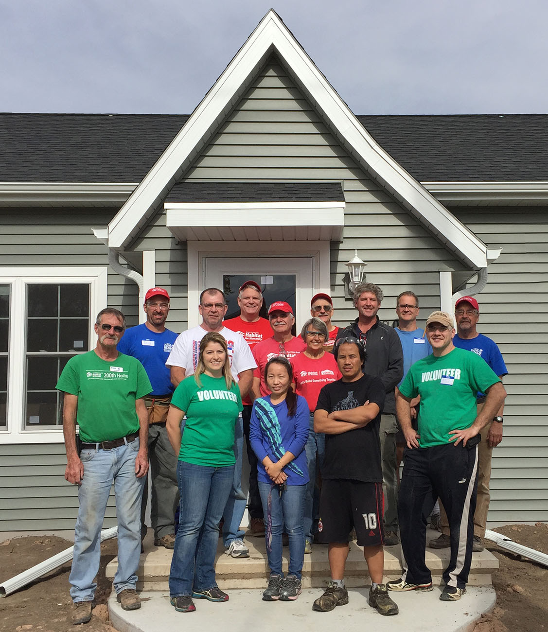 A group of people standing in front of a house