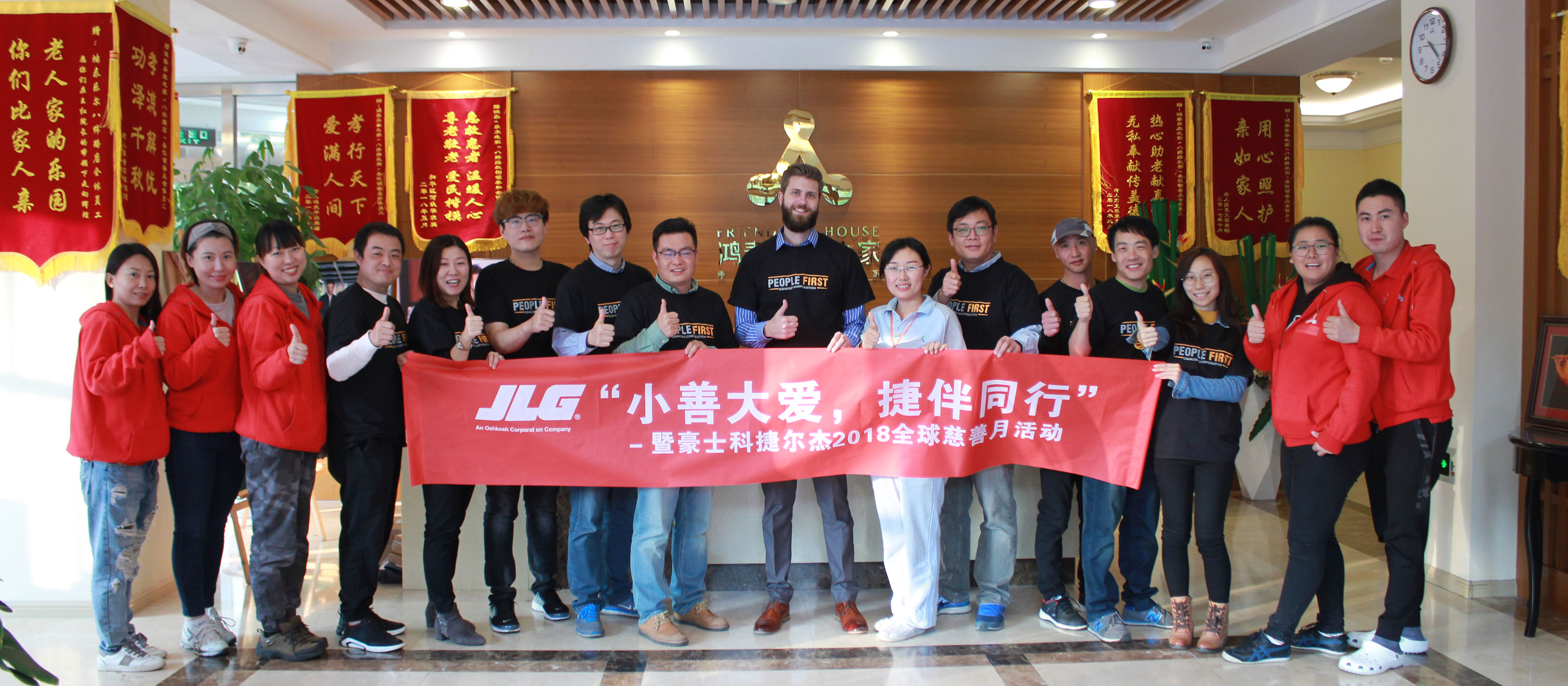 A group of people holding a red banner