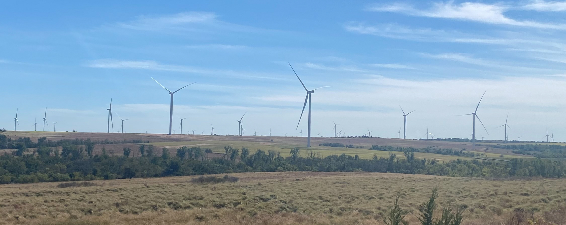 Windmills on a wind farm on a cloudy and blue sky day