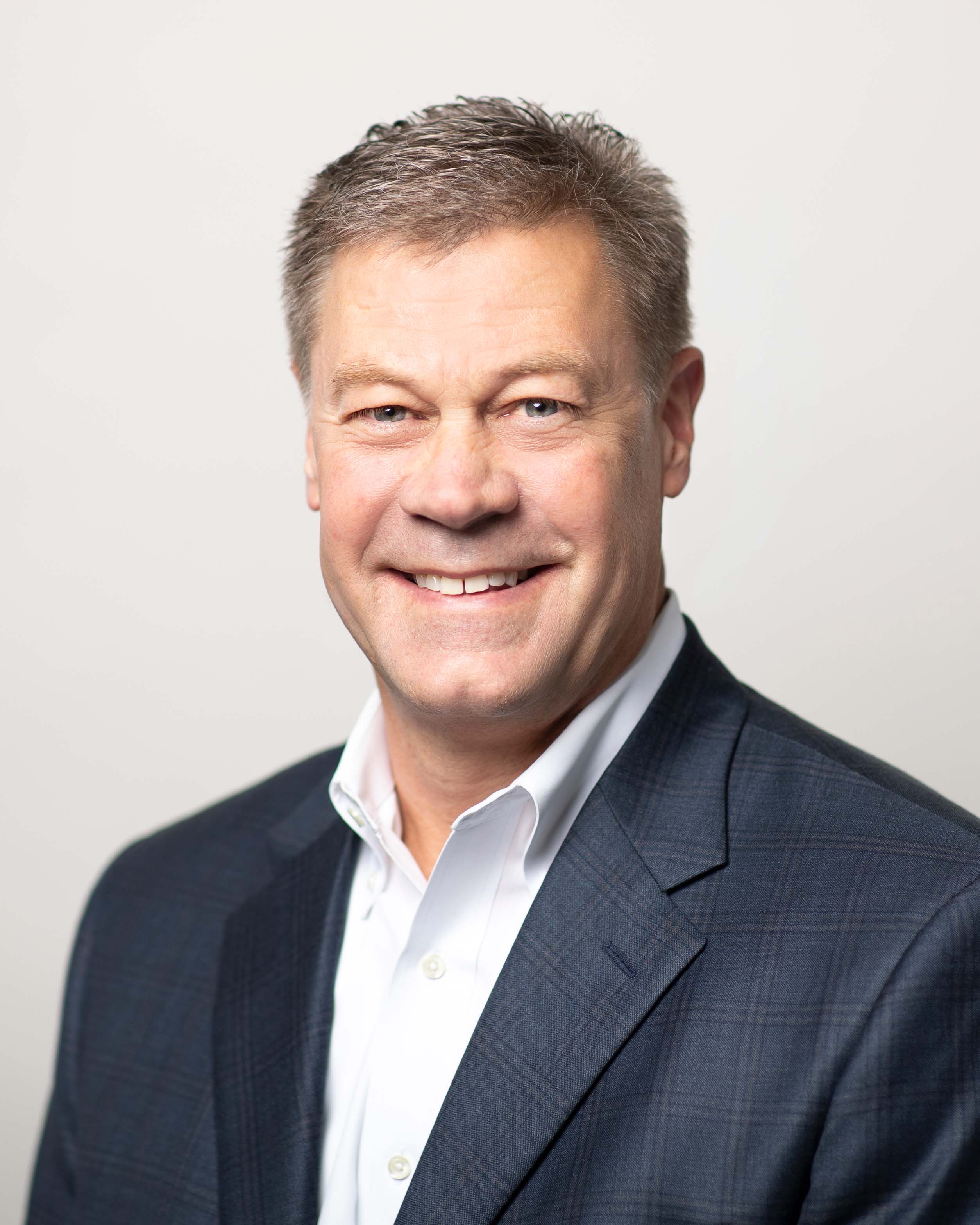 'Jim Johnson smiling and wearing a dark navy suit jacket'